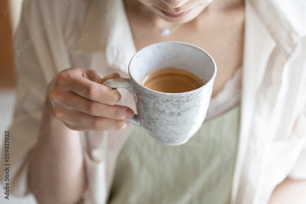 コーヒーを飲む女性の手元 コーヒーを飲む女性の手元