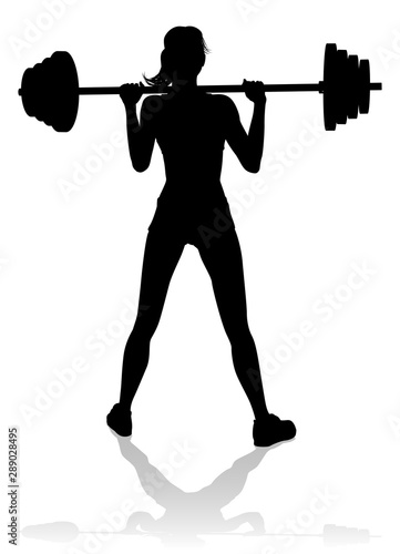 A woman in silhouette using barbell weights fitness exercise gym equipment