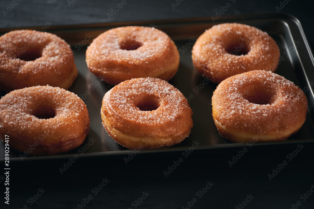 Donuts with sugar on a tray in a bar Donuts with sugar on a tray in a bar