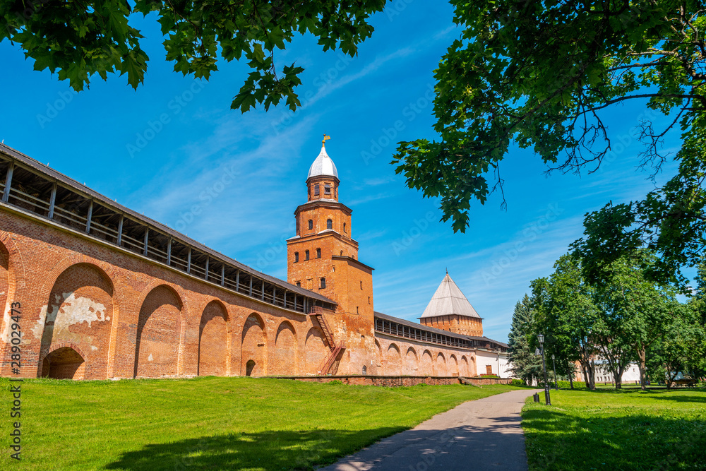 Veliky Novgorod, Russia. View of Kremlin wall and Kokui Tower with green trees at summer day.