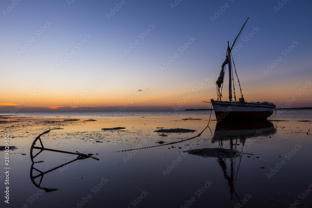 Sunset reflection of a stranded traditional fishing boat