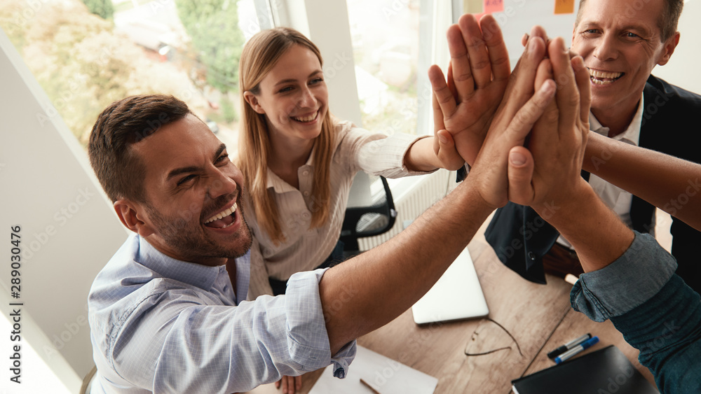 Successful team Business people giving each other high-five and smiling ...