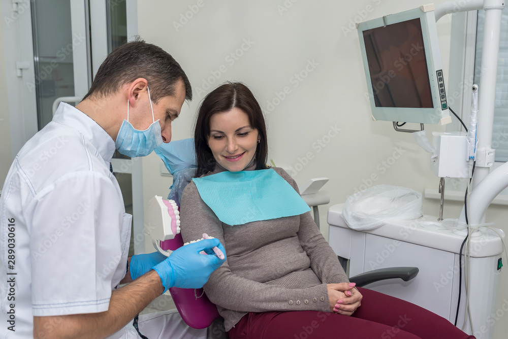Woman in dentistry pointing at teeth sampler Woman in dentistry pointing at teeth sampler