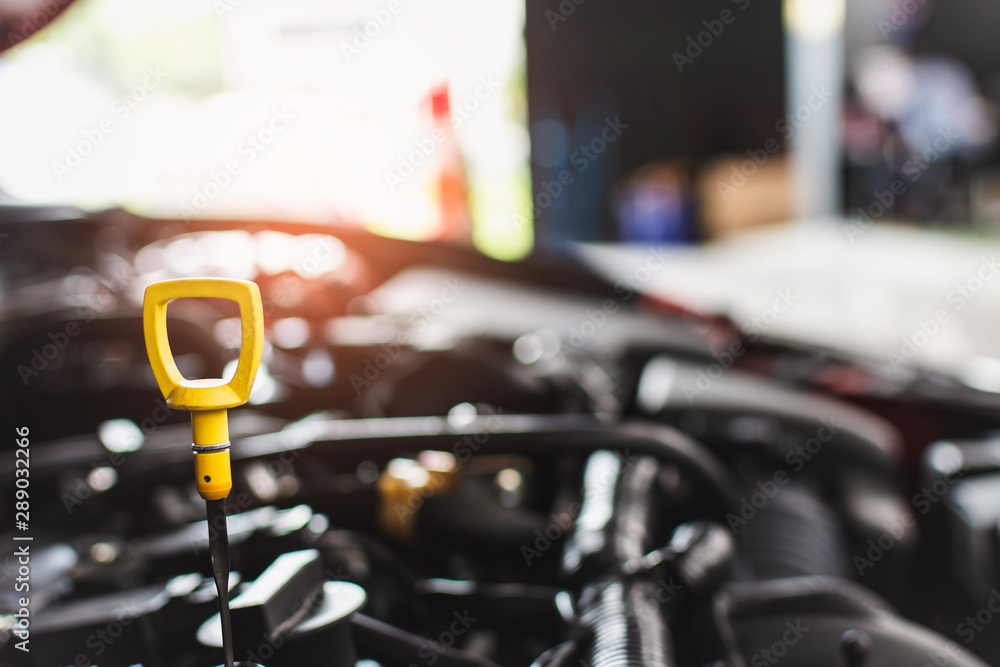 Man service mechanic maintenance inspection service maintenance car Check engine oil level car in garage showroom dealership blurred background. Man service mechanic maintenance inspection service maintenance car Check engine oil level car in garage showroom dealership blurred background.