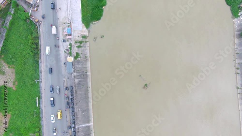 4k view over the roadway beside the wide uncleared water river. photo