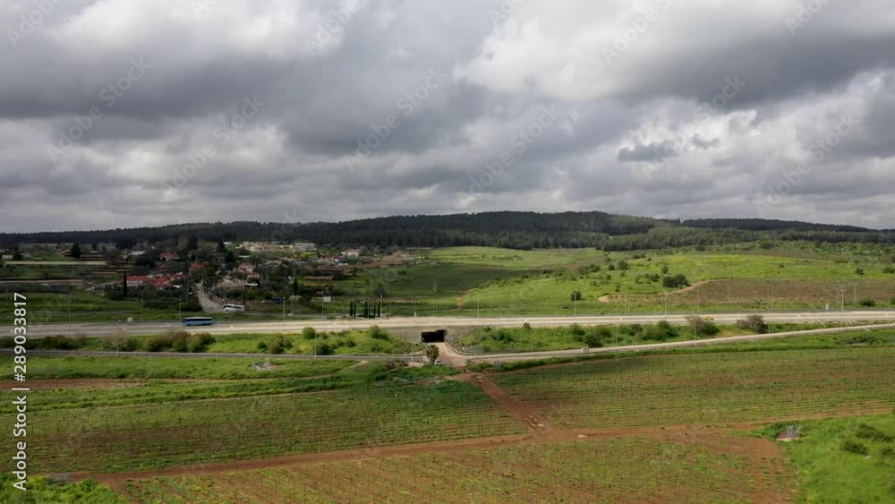 small road, cars cross, green field land, hills background, cloudy day. Israel small road, cars cross, green field land, hills background, cloudy day. Israel