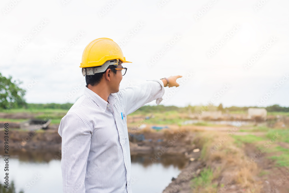 Man engineer hardhat standing Exploring new construction area. Rear view. Man engineer hardhat standing Exploring new construction area. Rear view.