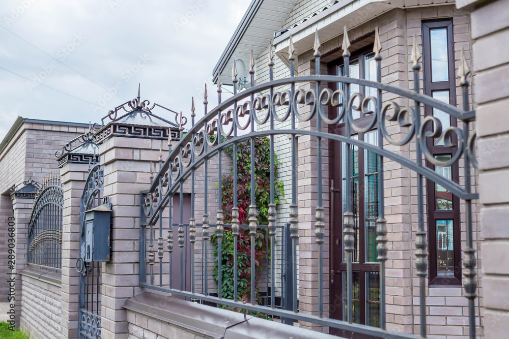 Forged decorative iron fence. Beautiful decorative wrought fence with artistic forging Forged decorative iron fence. Beautiful decorative wrought fence with artistic forging