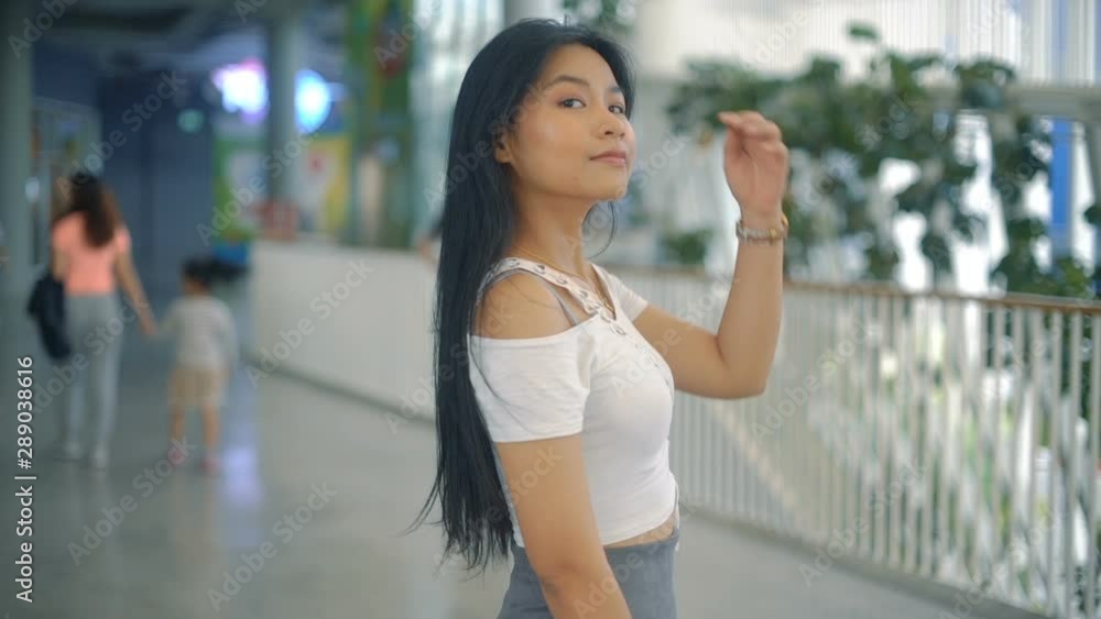 Young Asian Woman with long hair near shopping mall. Slow motion Young Asian Woman with long hair near shopping mall. Slow motion