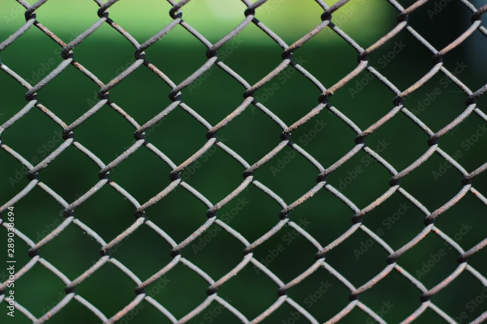 Fototapeta premium Chain link fence. Metal mesh fence closeup photo background. Fence chain texture