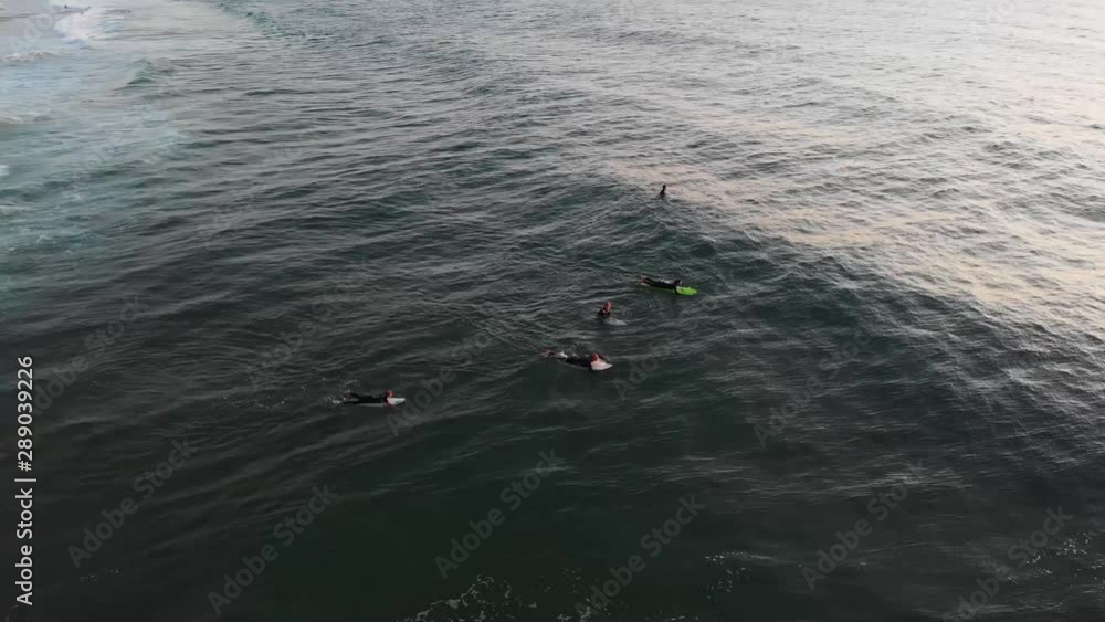 Aerial Drone Shot of Surfers Catching Waves out During Sunset Aerial Drone Shot of Surfers Catching Waves out During Sunset