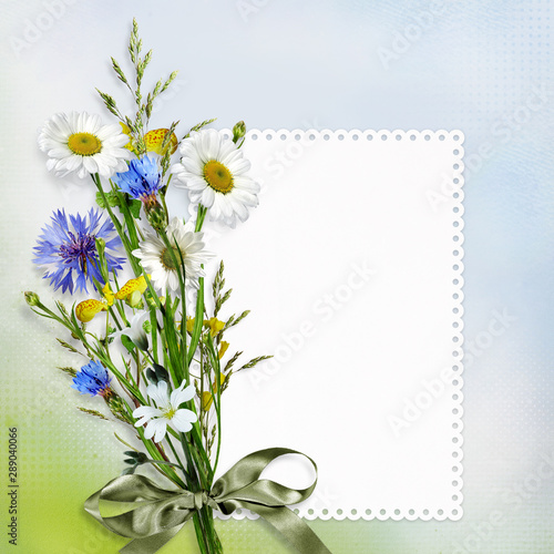 Beautiful vintage background with a bouquet of daisies and cornflowers with a card for text or photo