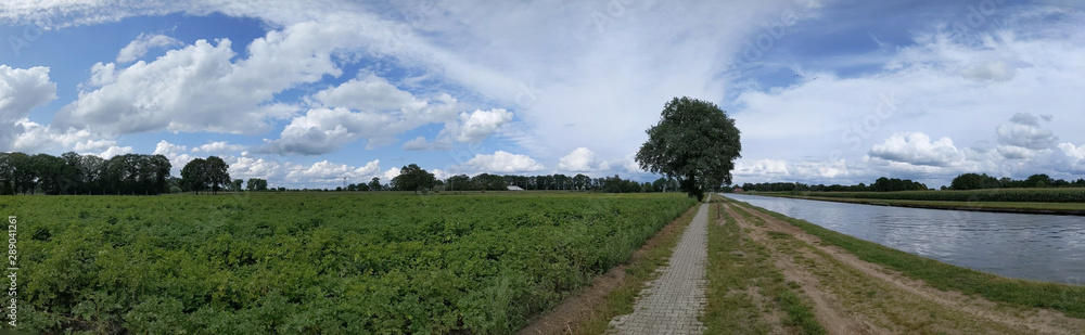 Fototapeta premium Panorama from a bicycle path next to a canal