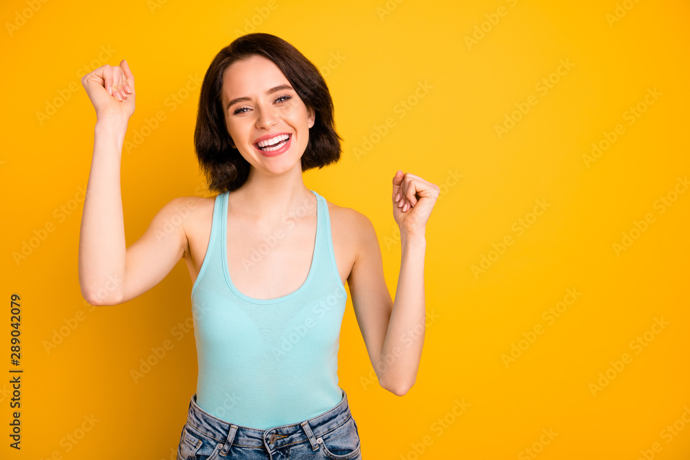 Photo of nice cheerful good glad girlfriend wearing jeans denim rejoicing with happiness of victory while isolated with yellow background Photo of nice cheerful good glad girlfriend wearing jeans denim rejoicing with happiness of victory while isolated with yellow background