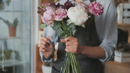 Florist making fresh flower bouquet in flower shop
