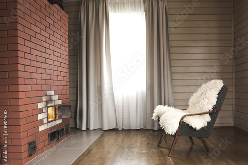 Farm Living room with fireplace, armchair, relaxation, comfort in wooden house. Dark interior, undoors. photo