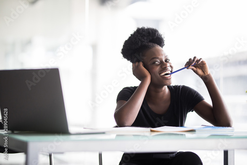 Close up portrait of a young woman working on laptop in modern office