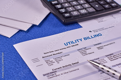Communal payments. Utility billing sheet, calculator, pen and envelopes on a blue velvet background