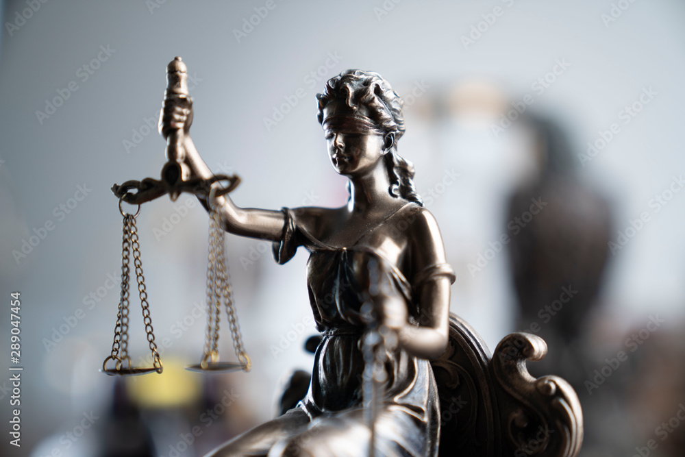 Law and justice theme. Themis statue on the bokeh background.