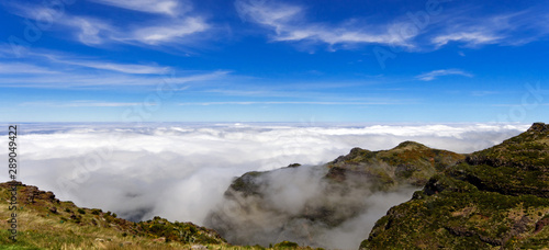 Wide angle shot of Mountain peaks in the clouds against blue sky from Pico Ruivo and Pico do Arieiro, beautiful mountain landscape, central Madeira, Portugal