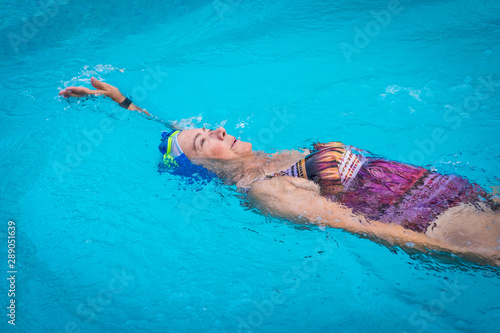 Фотография Elderly woman in activity swimming in backstroke style