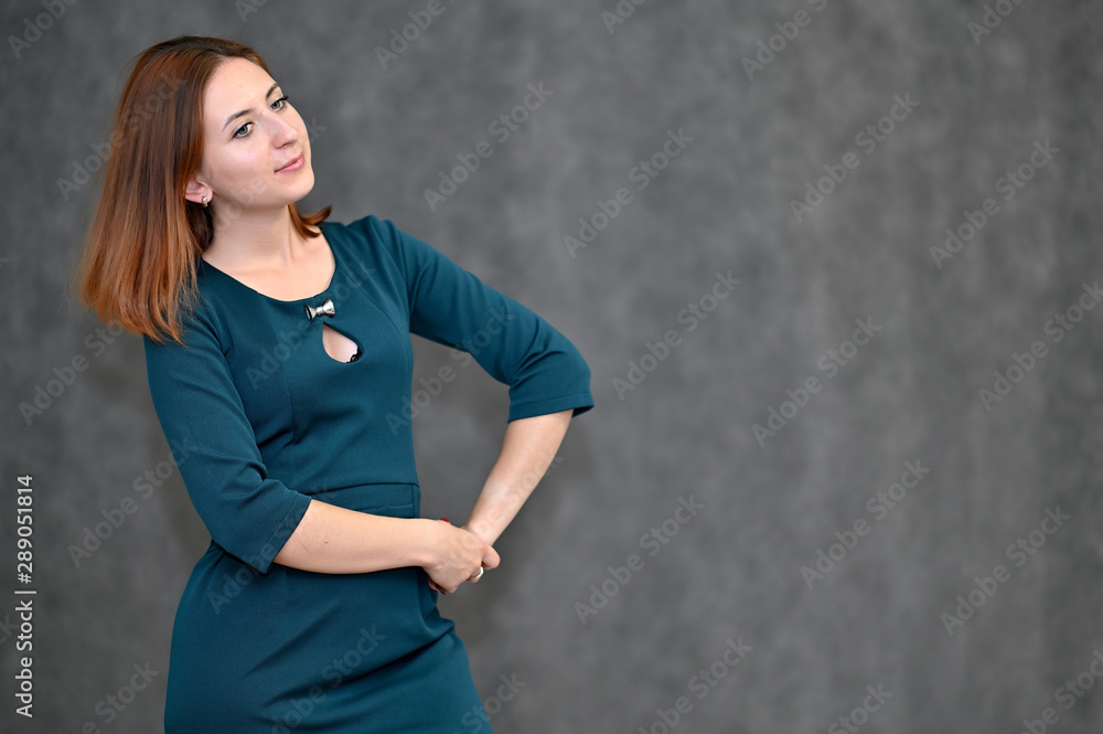 Portrait of a brunette girl with beautiful brown hair in a dark green dress on a white background. Standing in different poses, showing emotions. Portrait of a brunette girl with beautiful brown hair in a dark green dress on a white background. Standing in different poses, showing emotions.