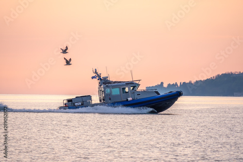 A coast guard patrol boat sails near the shore