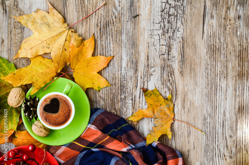 Autumn coffee. Autumn or Fall morning coffee concept. Flat-lay of knitted woolen grey sweater, wooden tray, mug of coffee and yellow fallen leaves over dark rustic wooden table background, top view