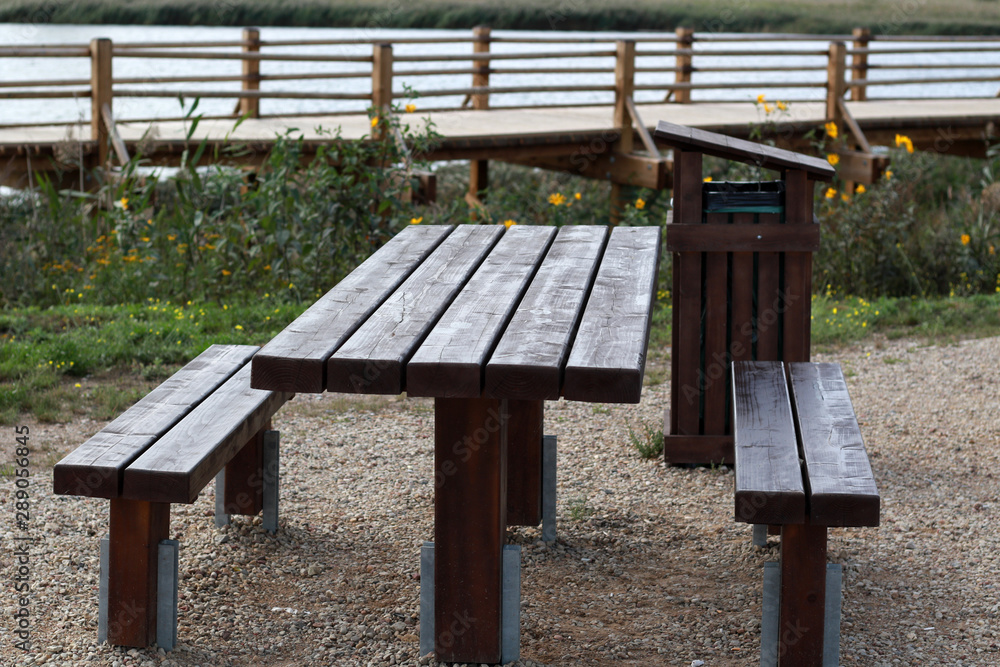 outdoor camping place with wooden table, bench and trash bin outdoor camping place with wooden table, bench and trash bin