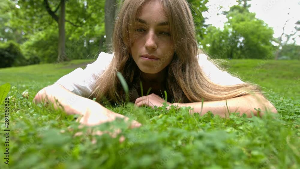 Woman laying in the grass, seductive reaching for the camera looking sexy. Woman laying in the grass, seductive reaching for the camera looking sexy.