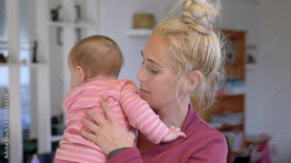 Mother in her house embracing and holding her baby girl, close up. Mother in her house embracing and holding her baby girl, close up.