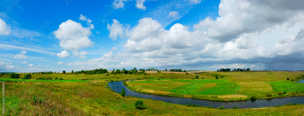 Beautiful panoramic landscape with river and green fields