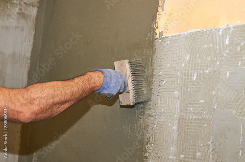 Applying layer of isolation material with a brush on a wall