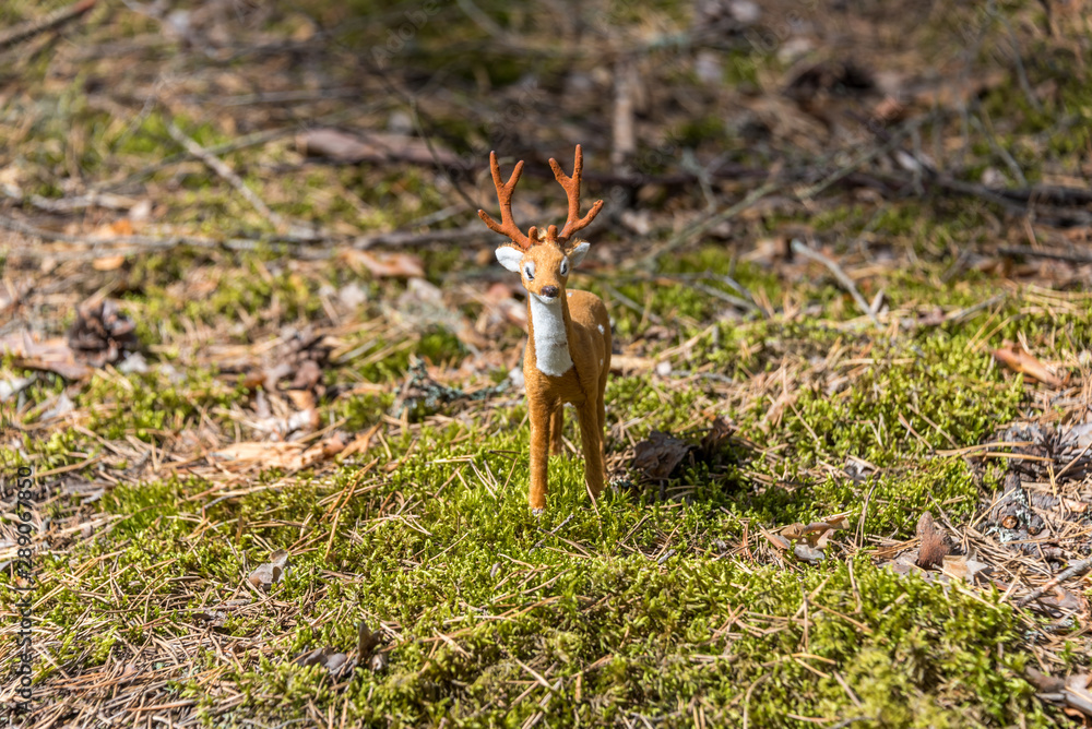 Little Toy Deer in a Green Forest on a Sunny Day Little Toy Deer in a Green Forest on a Sunny Day