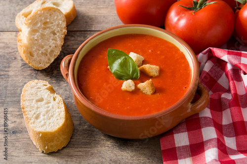 Tomato soup in brown bowl on wooden table