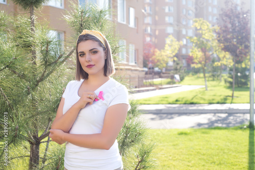 The girl holding a pink ribbon, symbol of cancer. Breast cancer awareness month.Strong woman fights cancer.