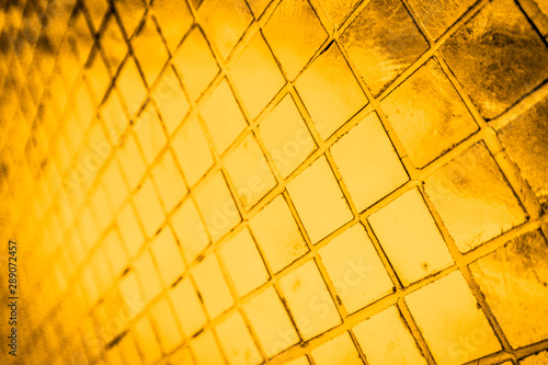 Beautiful closeup textures abstract color dark yellow and gold tiles granite and gold glass pattern wall and background and art