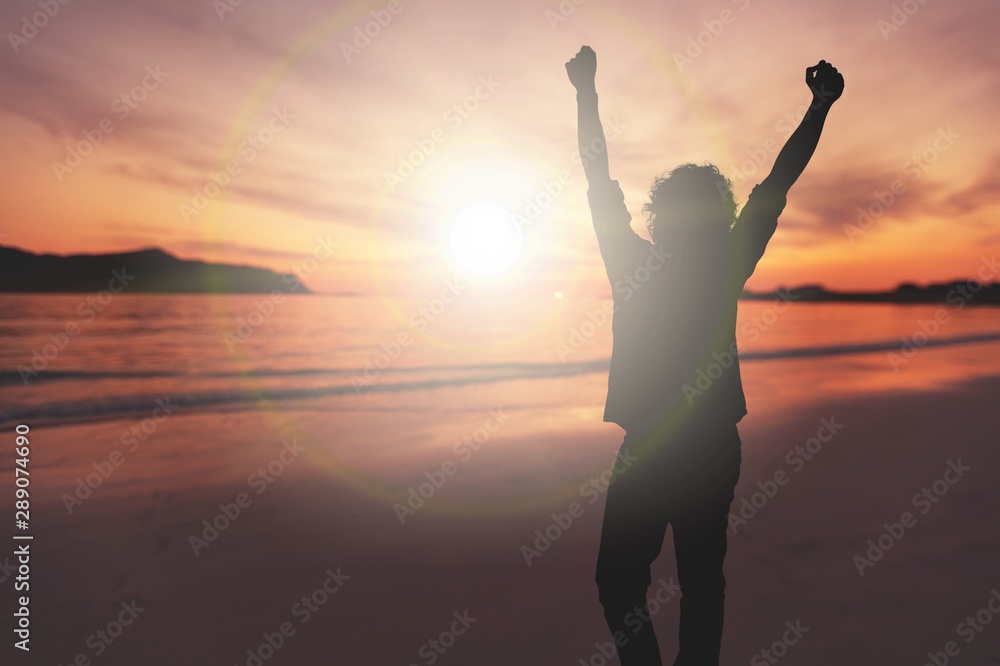 Happy young man on seacoast in sunset