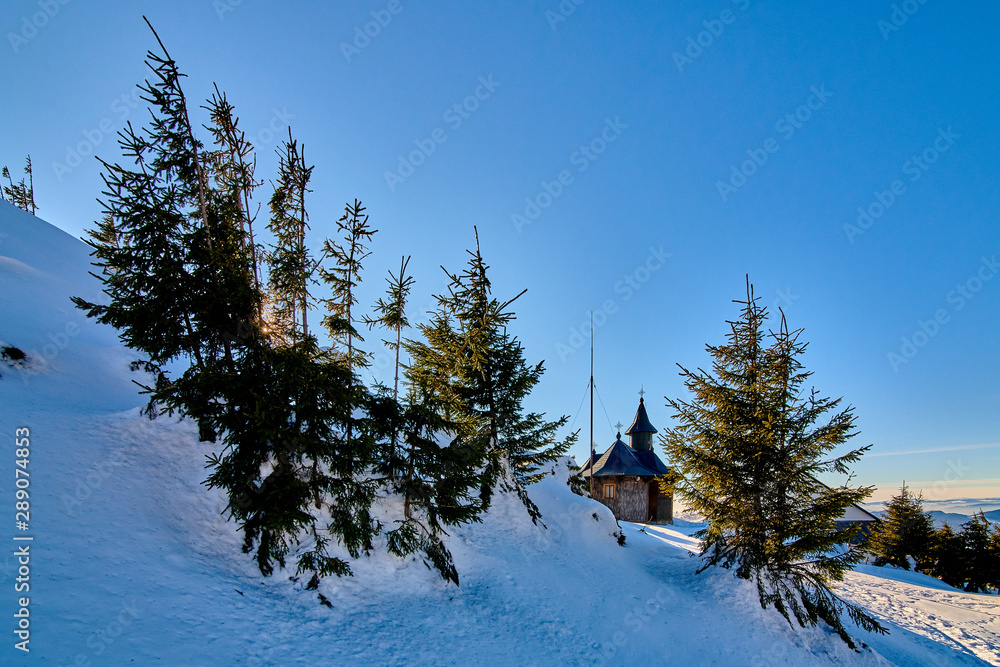 Fototapeta premium A little beautiful church in Ceahlau mountains, Landscape view from Ceahlău Mountains National Park in winter season