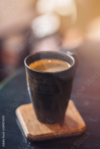 Vertical shot of a cup of coffee. Coffee Americano on wooden table in coffee shop cafe. Selective focus. The Americano tends to stand out because it has absolutely no milk in it.