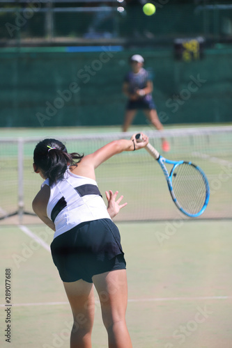 サーブを打つ女子テニスプレイヤー © DOUBLE BAGEL
