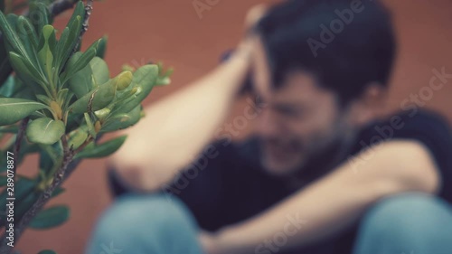 defocused Desperate depressed young man crying alone- outdoor photo