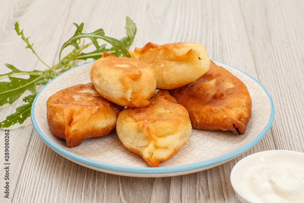 Plate with fried pies on wooden boards