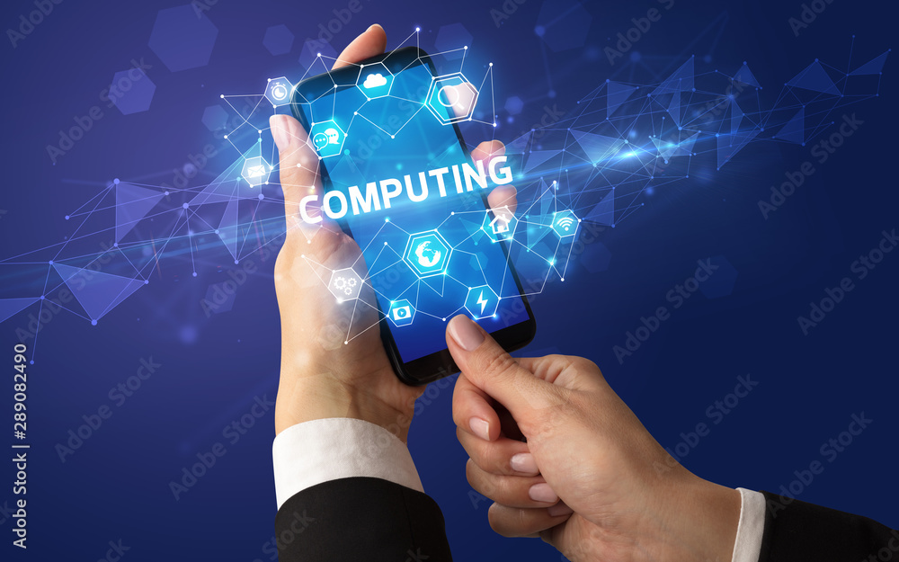 Female hand holding smartphone with COMPUTING inscription, modern technology concept Female hand holding smartphone with COMPUTING inscription, modern technology concept
