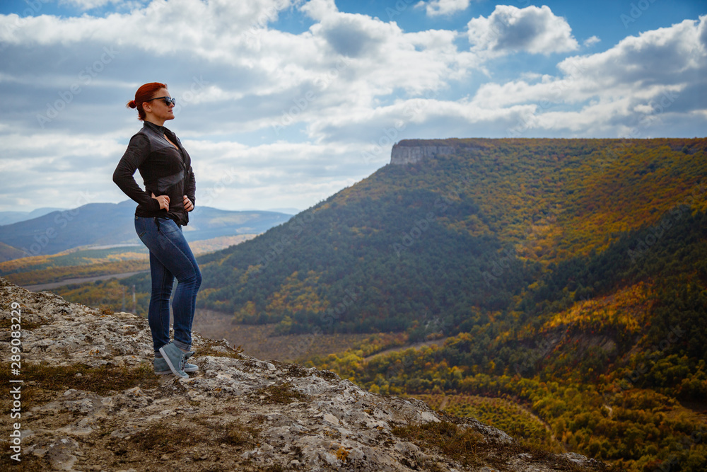 Red-haired elegant lady with closed eyes resting in nature in the mountains in the meadow Red-haired elegant lady with closed eyes resting in nature in the mountains in the meadow