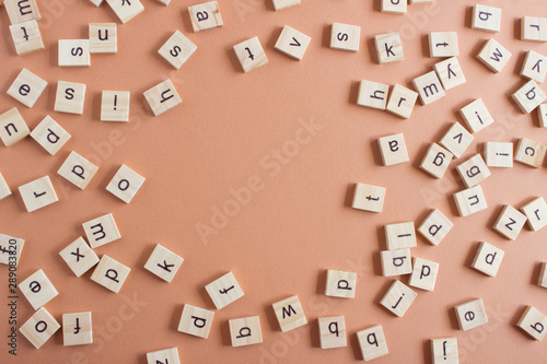 Random wooden letters on coral background