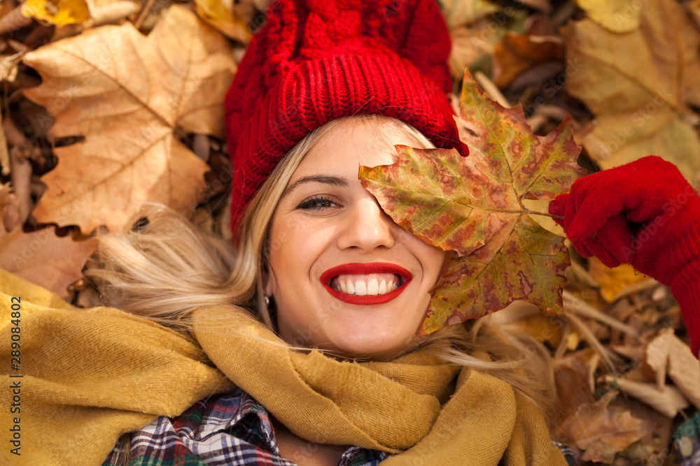 Nice smiling woman playing with autumn leaves Nice smiling woman playing with autumn leaves