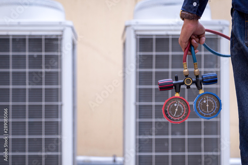 Technician is checking air conditioner ,measuring equipment for filling air conditioners.