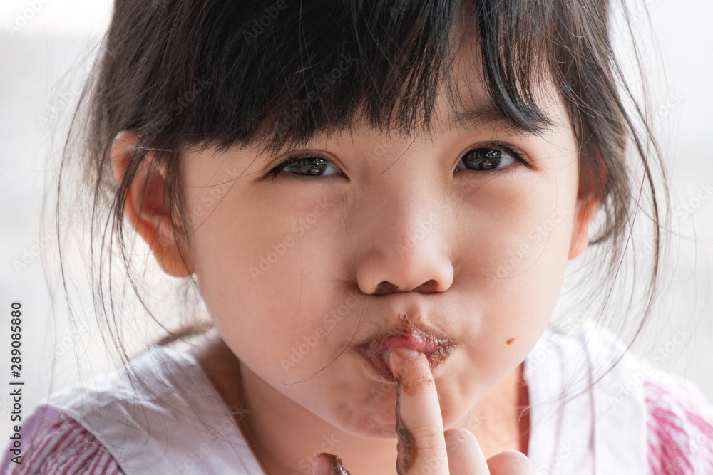Cute Little Asian Girl Eat Chocolate.