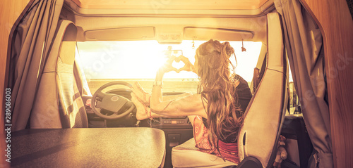 Frau macht ein Herz aus Händen im Camper